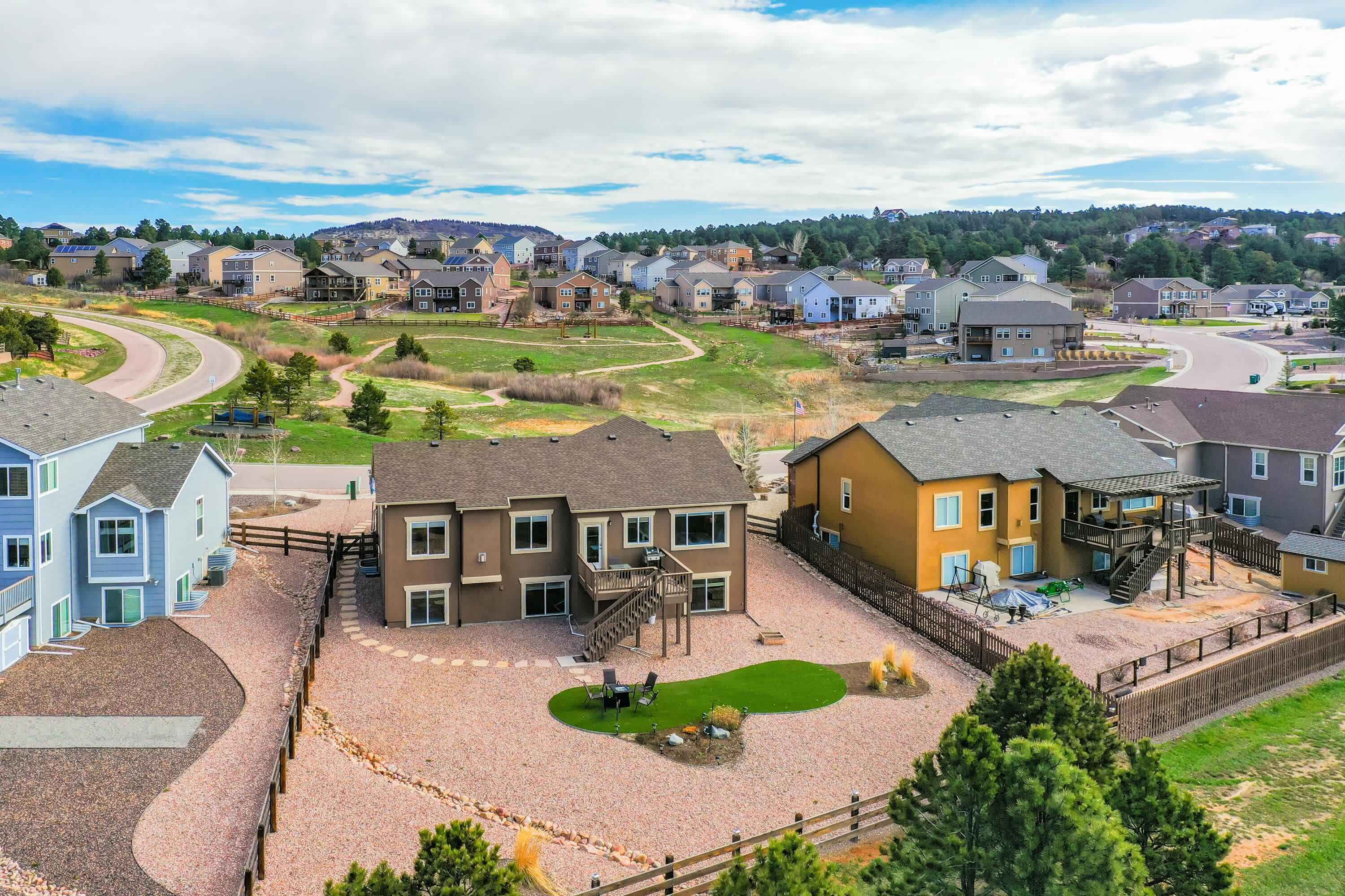 A residential area with houses, a central courtyard, and a winding road.