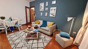 A living room with a sofa, a coffee table with board games, a patterned rug, and framed pictures on the wall. - Villa Christele Sanremo (Sanremo)