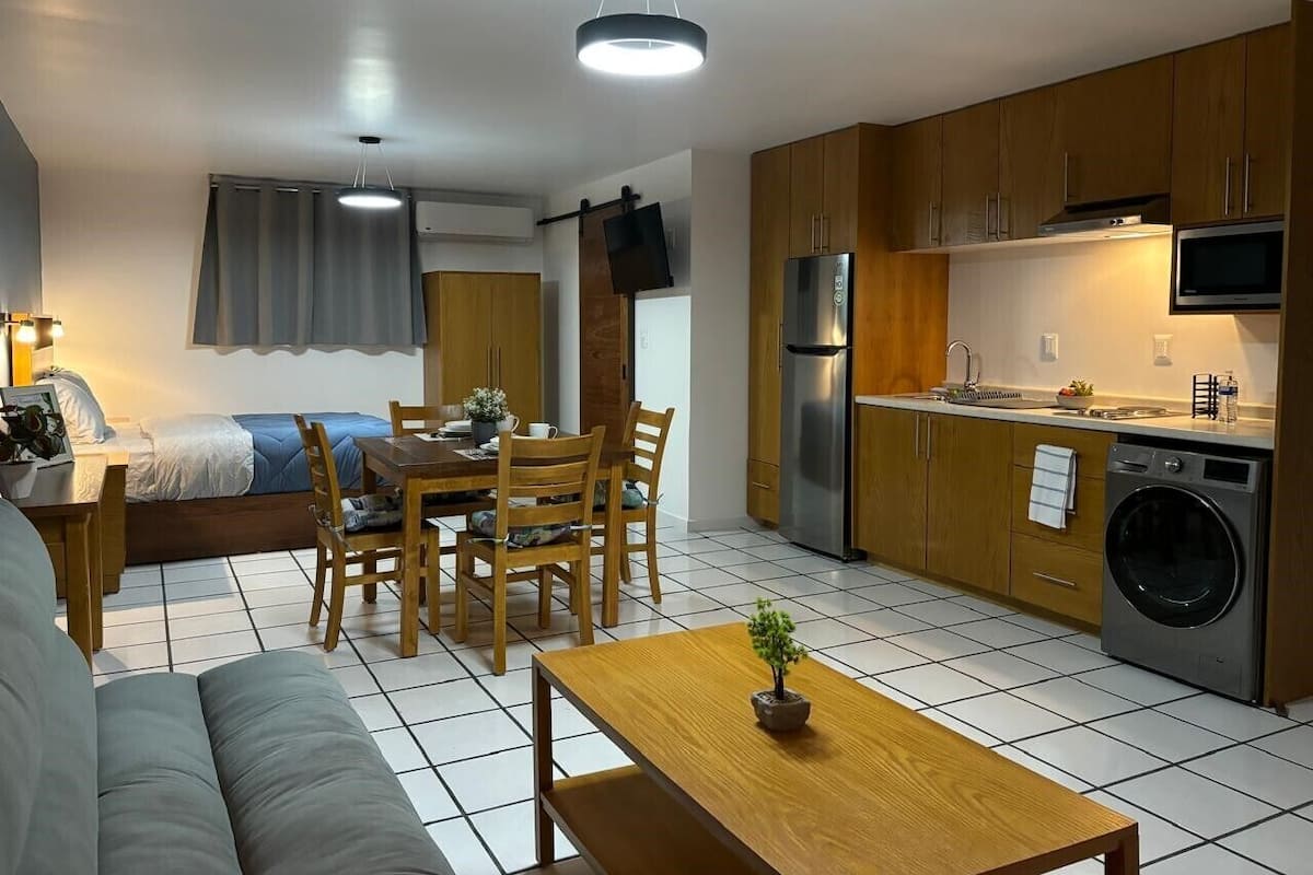 Um espaço compacto com cozinha americana, área de refeições e sofá.