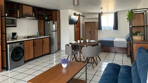 A compact living space with a kitchenette, a dining area, and a sofa.