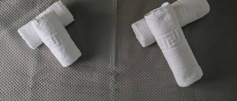 Two white towels on a textured grey surface.