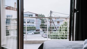 A room with a large window overlooking a parking area and buildings. - Crystal Studios (Aristotelis)