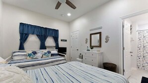 Un dormitorio con cama, cómoda, espejo y ventilador de techo.