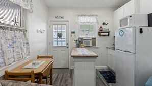 Una cocina compacta con una mesa de comedor, un refrigerador y un microondas.