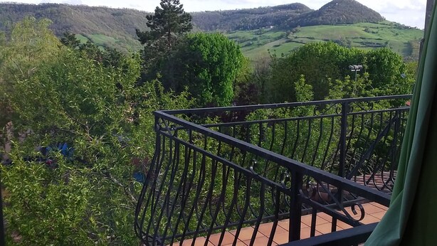 Un balcón con vistas a un paisaje verde y colinas.