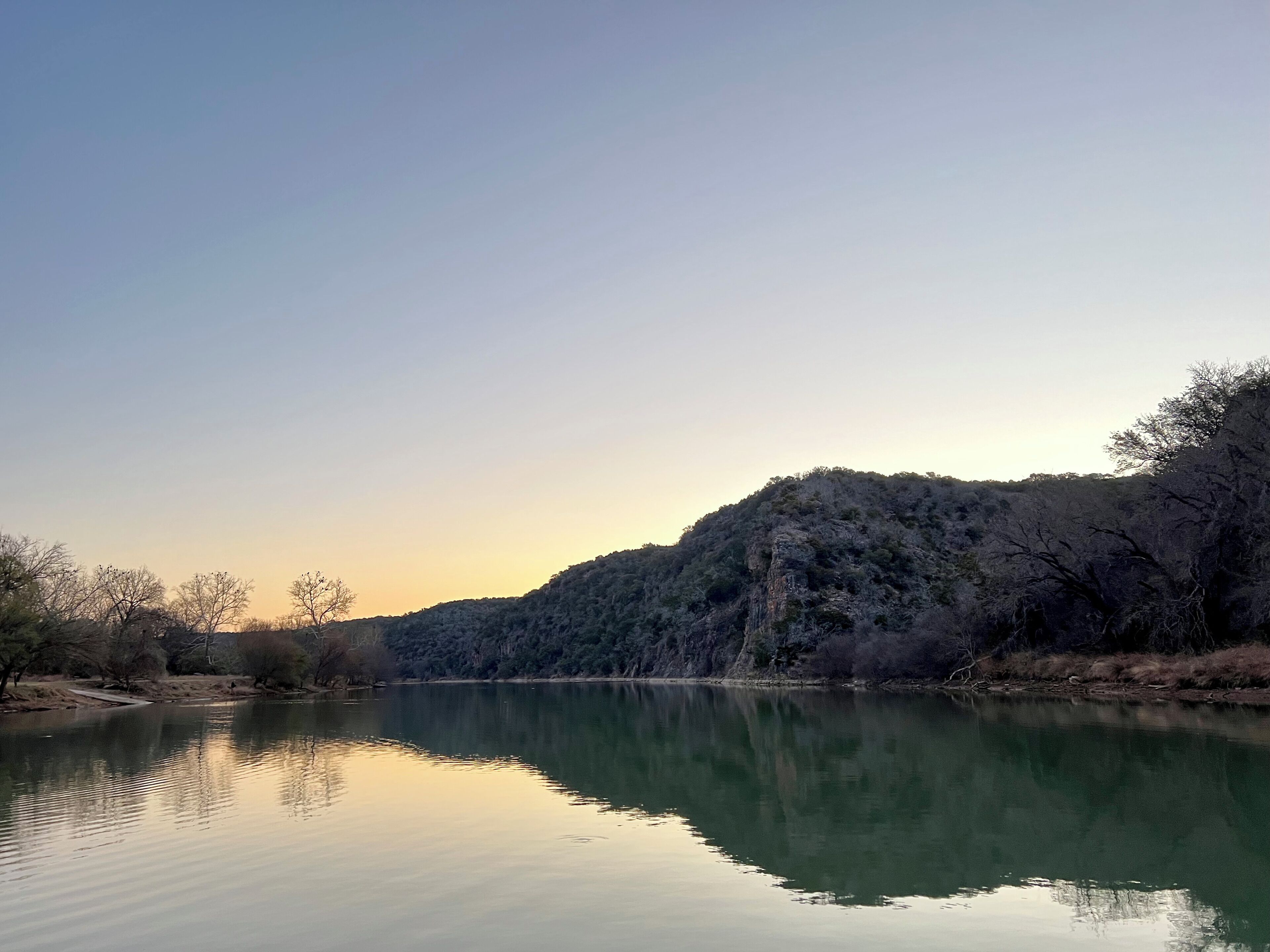 Breathe deeply beside glassy water and peaceful hill views.