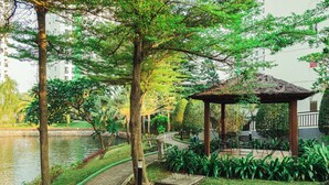 A tranquil park with a pond, a gazebo, and a pathway.