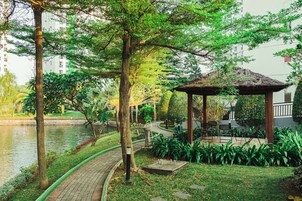 Um parque tranquilo com um lago, um coreto e um caminho.