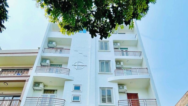 Un edificio de varios pisos con un letrero que dice "NHÀ KHÁCH LOTUS 2", indicando un hotel o casa de huéspedes.