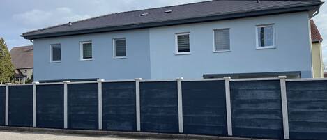 Un bâtiment à deux étages, doté d’un toit plat et de nombreuses fenêtres.