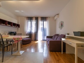 Un espacio habitable moderno con comedor, sofá y escritorio.