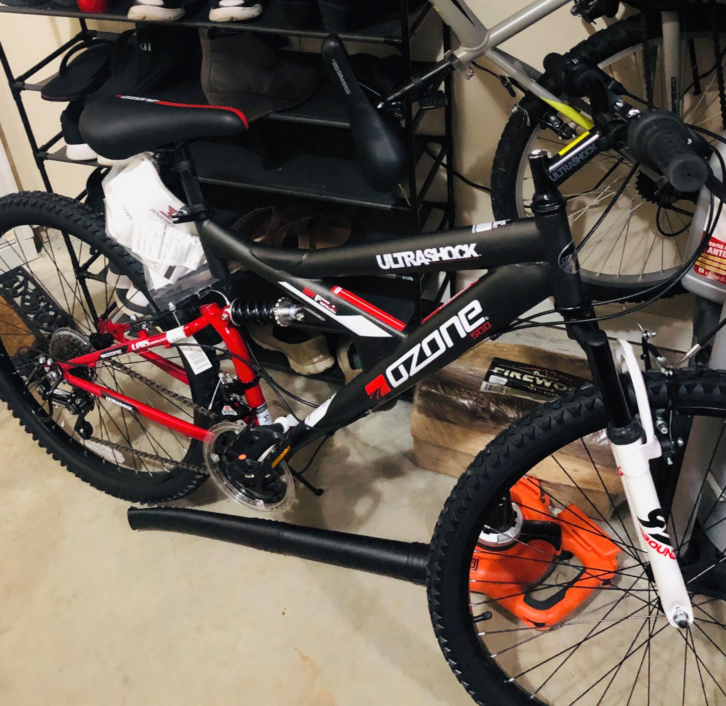 Un vélo arborant les marques « ULTRASHOCK » et « OZONE », avec un cadre rouge et une fourche avant blanche.