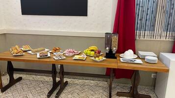 A buffet table with various food items and a beverage dispenser.
