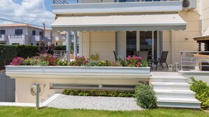 A two-story building with a balcony, outdoor seating, and a garden area with flowers. - Santa Barbara 2fl Home w. Garden and Intex Pool (Marathonas)