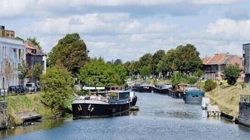 A canal with boats, surrounded by buildings and trees.