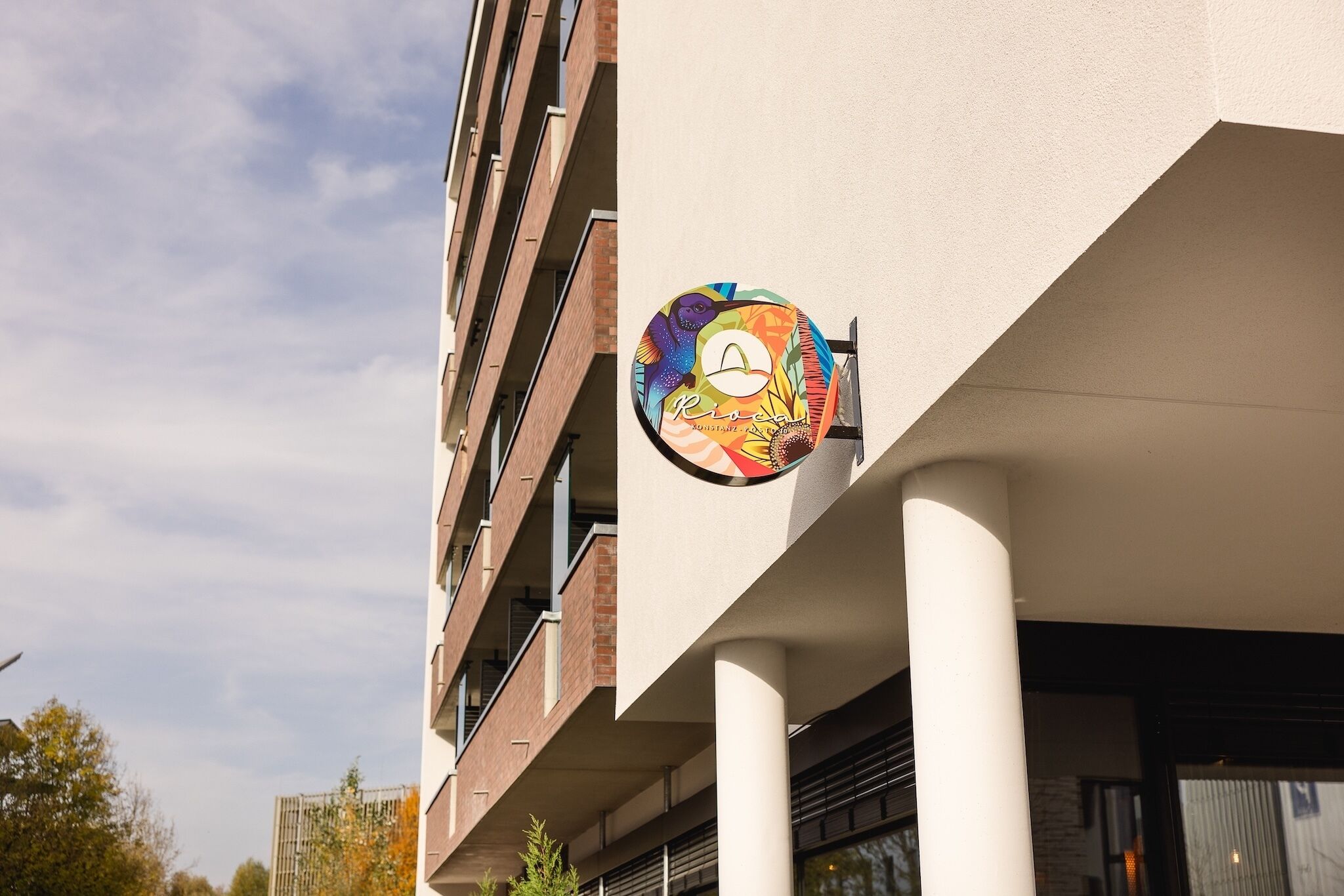 Un bâtiment orné d’une enseigne colorée représentant un visage stylisé et portant l’inscription « Rio de Janeiro ».