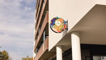 Un bâtiment orné d’une enseigne colorée représentant un visage stylisé et portant l’inscription « Rio de Janeiro ».