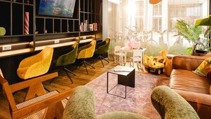 A modern living room with a TV, bookshelves, and a large window with a view of the city. - Rioca Konstanz Posto 10 (Konstanz)
