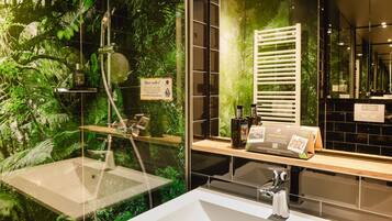 Een moderne badkamer met een wastafel met glazen ombouw, een douche met glazen deur en een spiegel die de ruimte weerspiegelt.