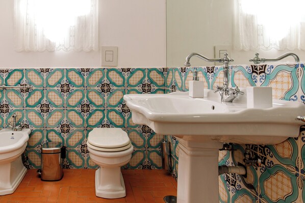 A bathroom with a sink, two toilets, and a trash can. - Villa Serao by MyVillaCollection (Ischia Porto)