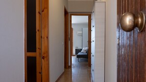 A hallway with wooden doors and a bed in the background. - Apple House (Giardini Naxos)