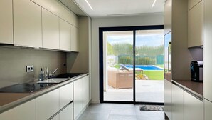 Una cocina moderna con puertas correderas que dan a una zona de piscina.