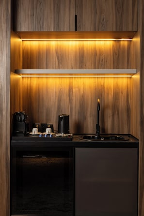 Efficient kitchen space with stove, stainless steel sink, and refrigerator.