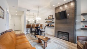 A modern living room with a leather sofa, a wooden coffee table, and a fireplace. - Pet Friendly Condo, Suncadia Pool Access (Cle Elum)