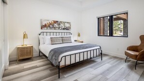 A bedroom with a bed, two bedside tables, a chair, a window, and a painting on the wall. - Family Friendly w/ Suncadia Pool Access (Cle Elum)