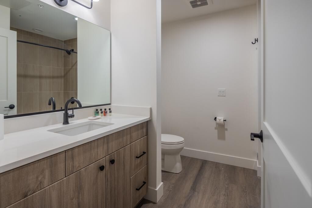 Un baño moderno con tocador doble, inodoro y zona de ducha.
