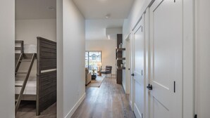 A hallway with a wooden staircase, a sofa, and a chair. - Family Friendly w/ Suncadia Pool Access (Cle Elum)