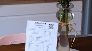 A menu on a table with a floral centerpiece.