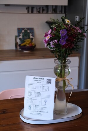 A menu on a table with a floral centerpiece. - Maison Bossanne (Barbières)
