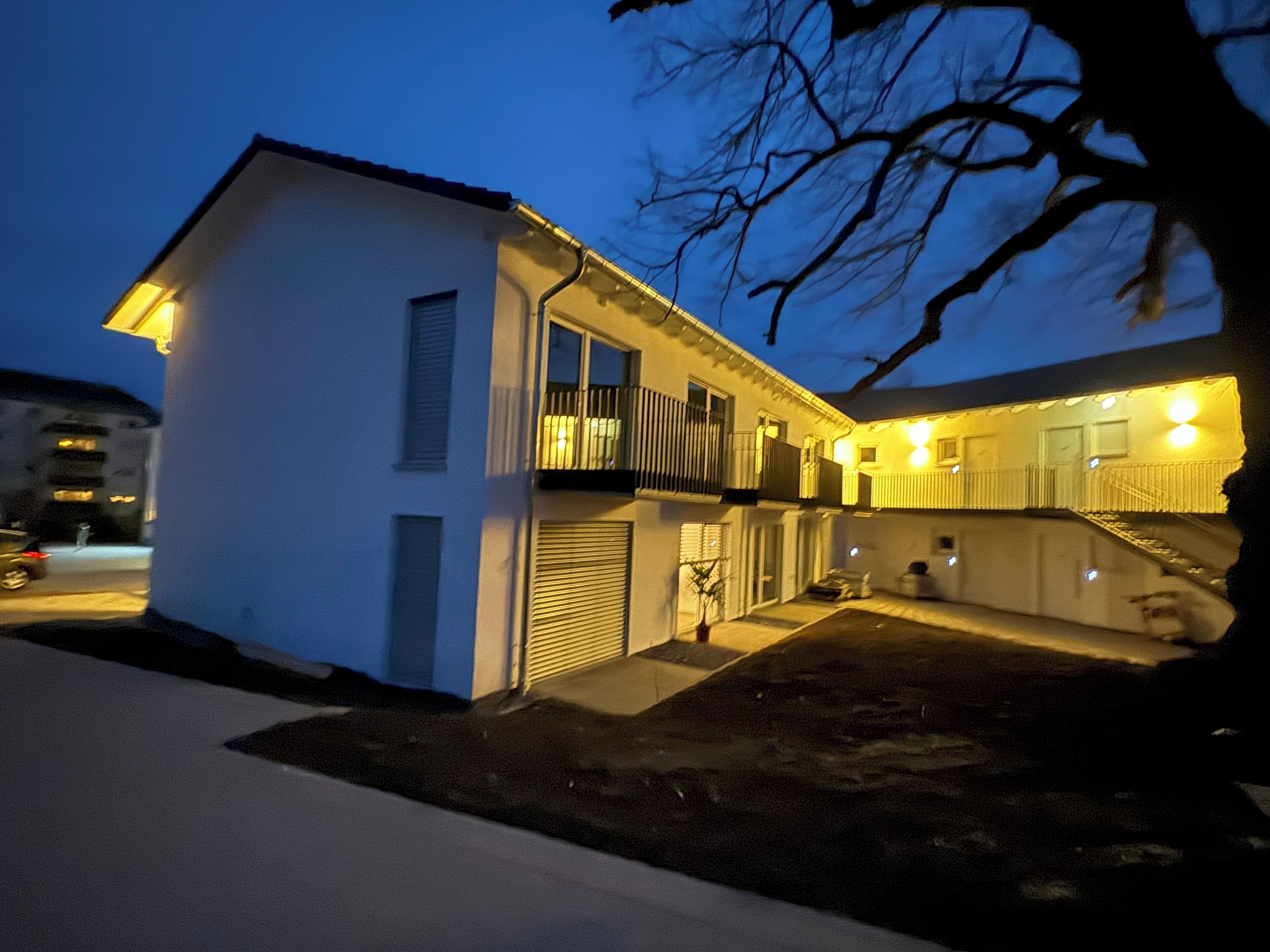 Ein zweistöckiges Haus mit Balkon und Garage.