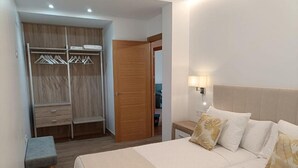 A bedroom with a bed, bedside tables, a wardrobe, and a bench.