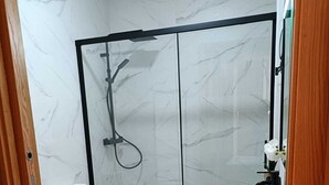 A bathroom with a shower, toilet, and sink.
