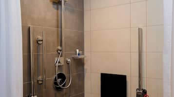 A modern shower area with a handheld showerhead, a wall-mounted faucet, and a handheld showerhead.