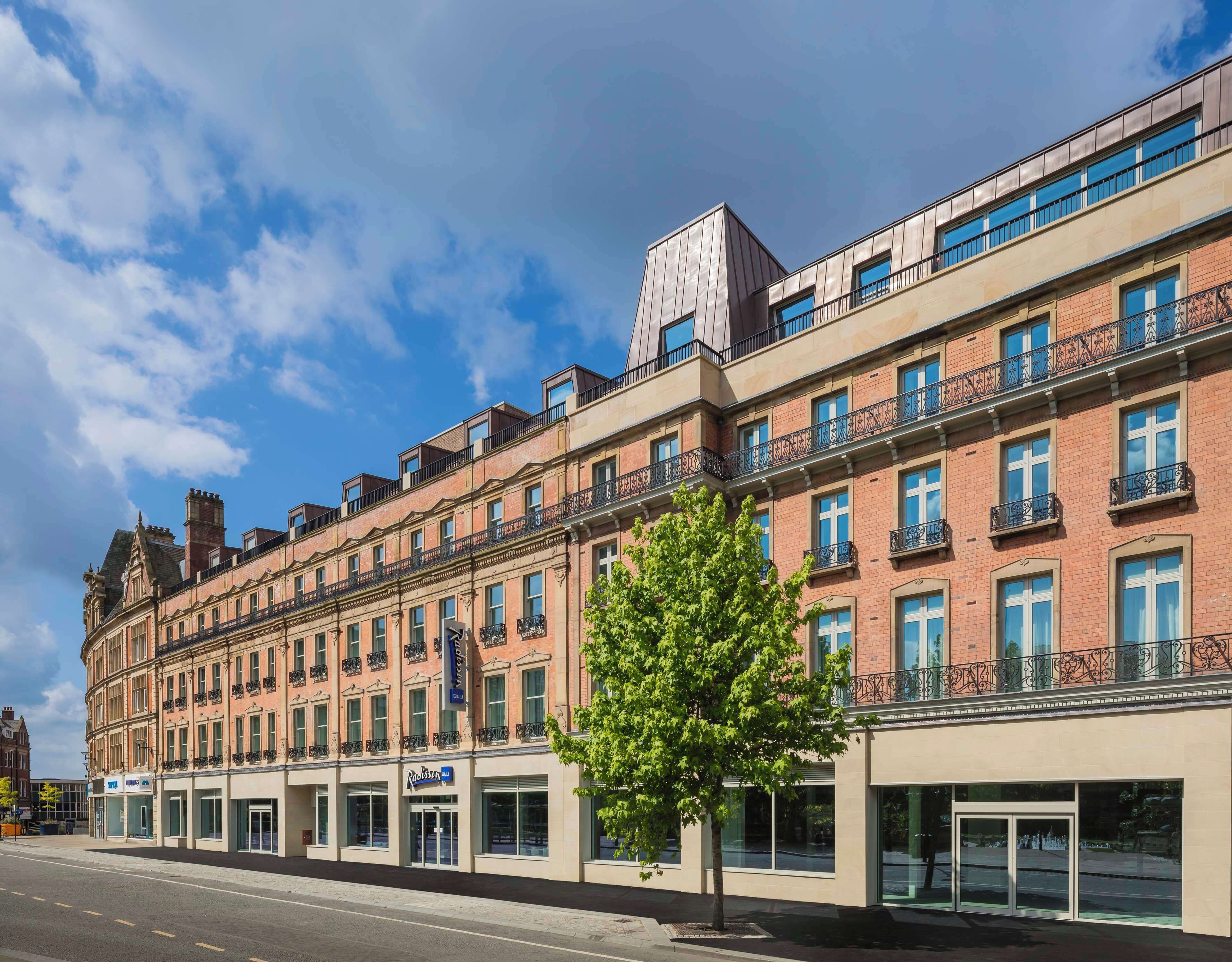 A multi-story hotel with a classic facade, featuring a mix of brick and modern glass elements.