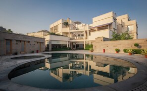 A modern building with a central courtyard and a reflective pool. - Naad Wellness (Sonepat)