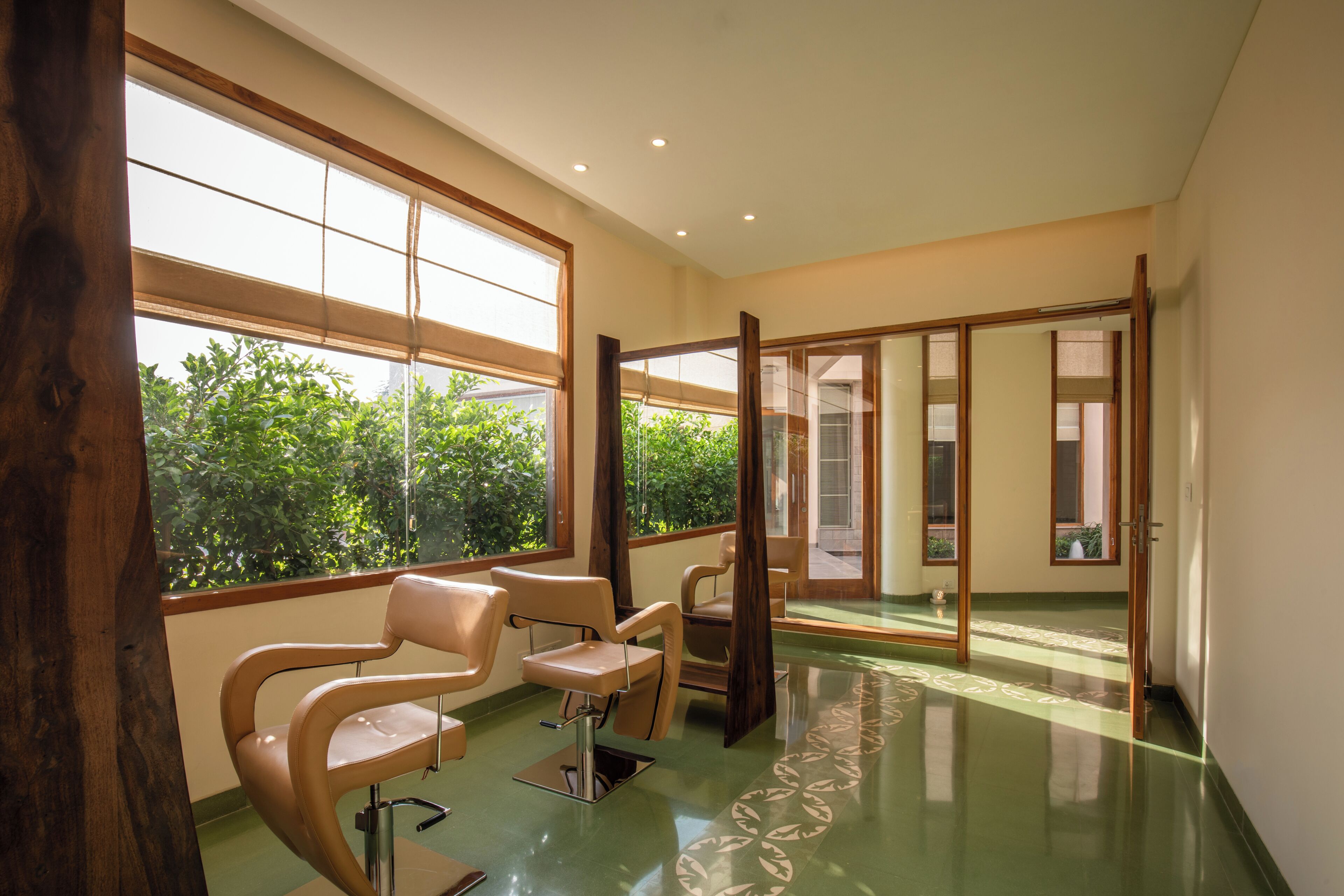 A spacious room with large windows, a chair, and a mirror.