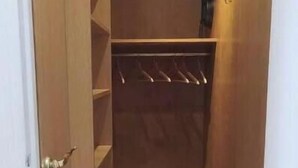A narrow walk-in closet with wooden shelving and a shoe rack. - Charmant Appartement au Pied D'un Parc Arboré (Clichy)