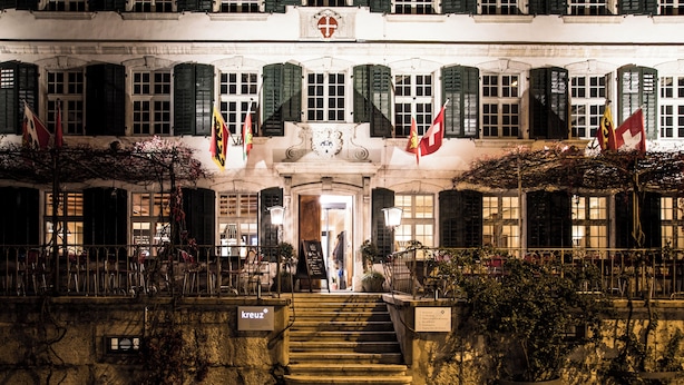 Un bâtiment historique doté d’une entrée imposante, de nombreux drapeaux et d’un escalier menant à l’entrée.