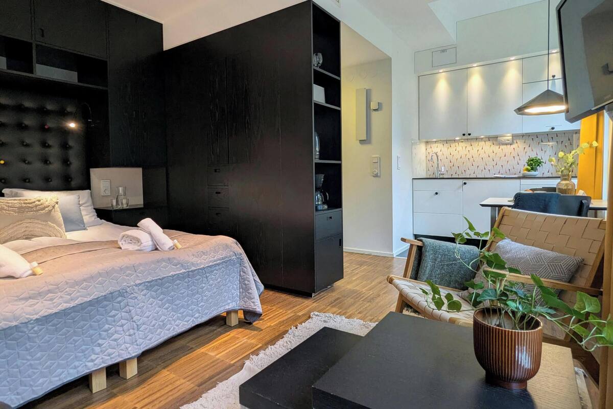 Une chambre à coucher moderne avec un lit, une table de chevet et un petit bureau.