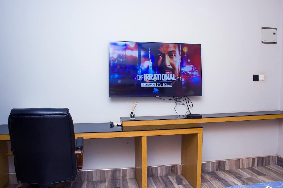 A modern office space with a flat-screen TV displaying 'The Irrational S1'.