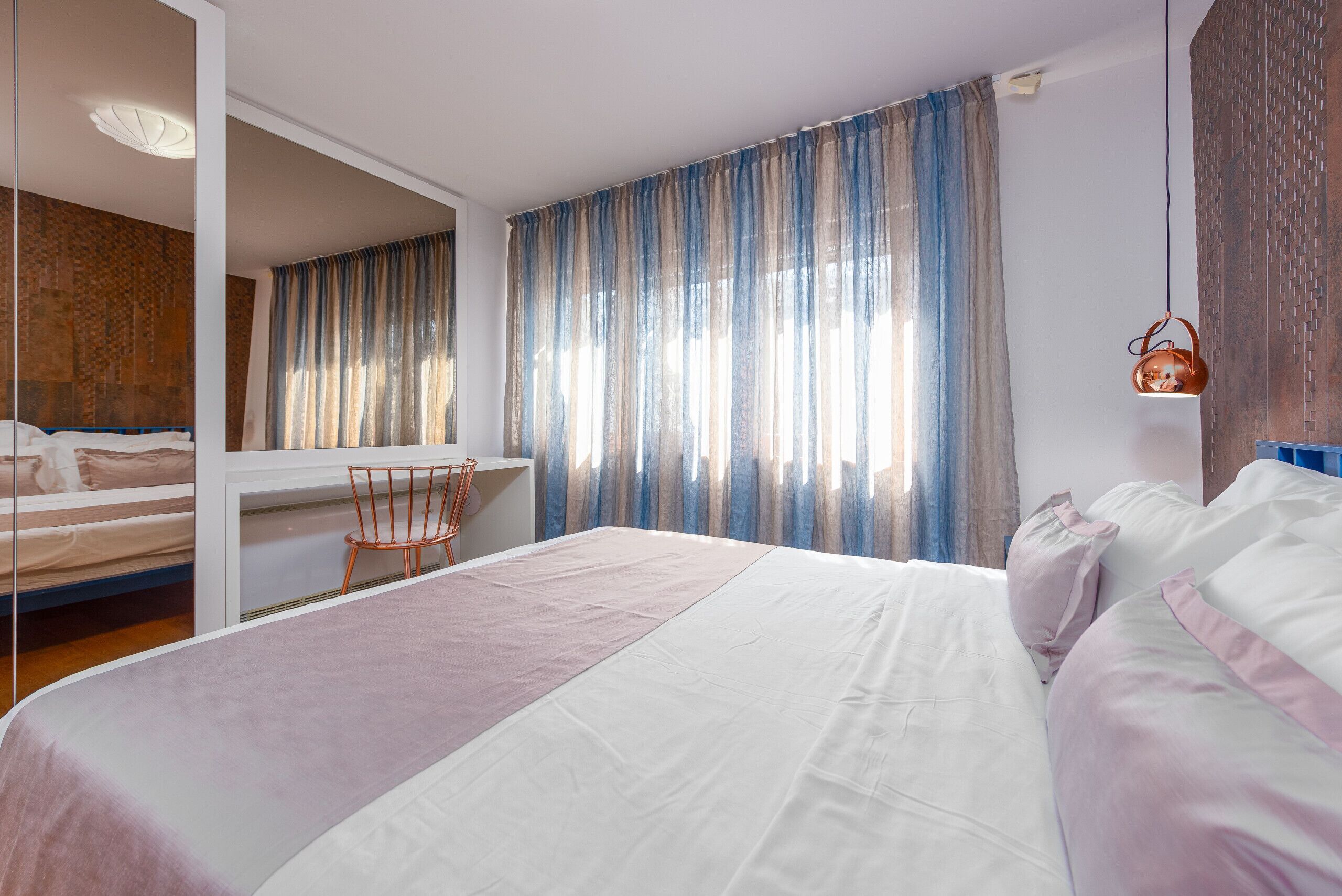 Habitación de hotel moderna con una cama grande, un escritorio y una silla.