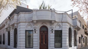 A historic building with a prominent arched entrance, large windows, and a number '5901' above the door.