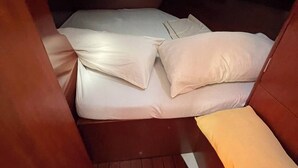 Una cabaña pequeña con una cama individual, suelo de madera y un ventanal.