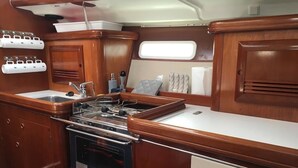 Una cocina compacta equipada con fregadero, cocina, horno y un refrigerador pequeño.