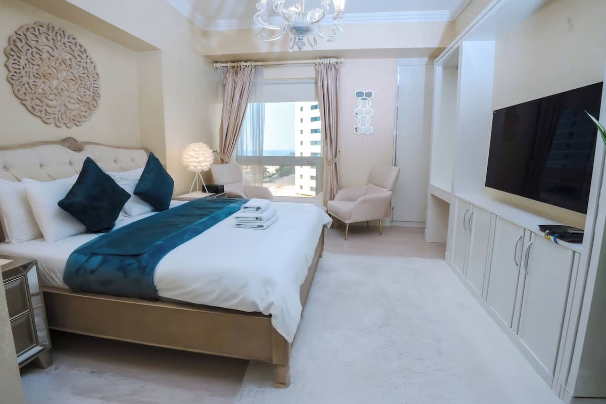 Une chambre moderne avec un grand lit, une télévision et une vue sur la ville.