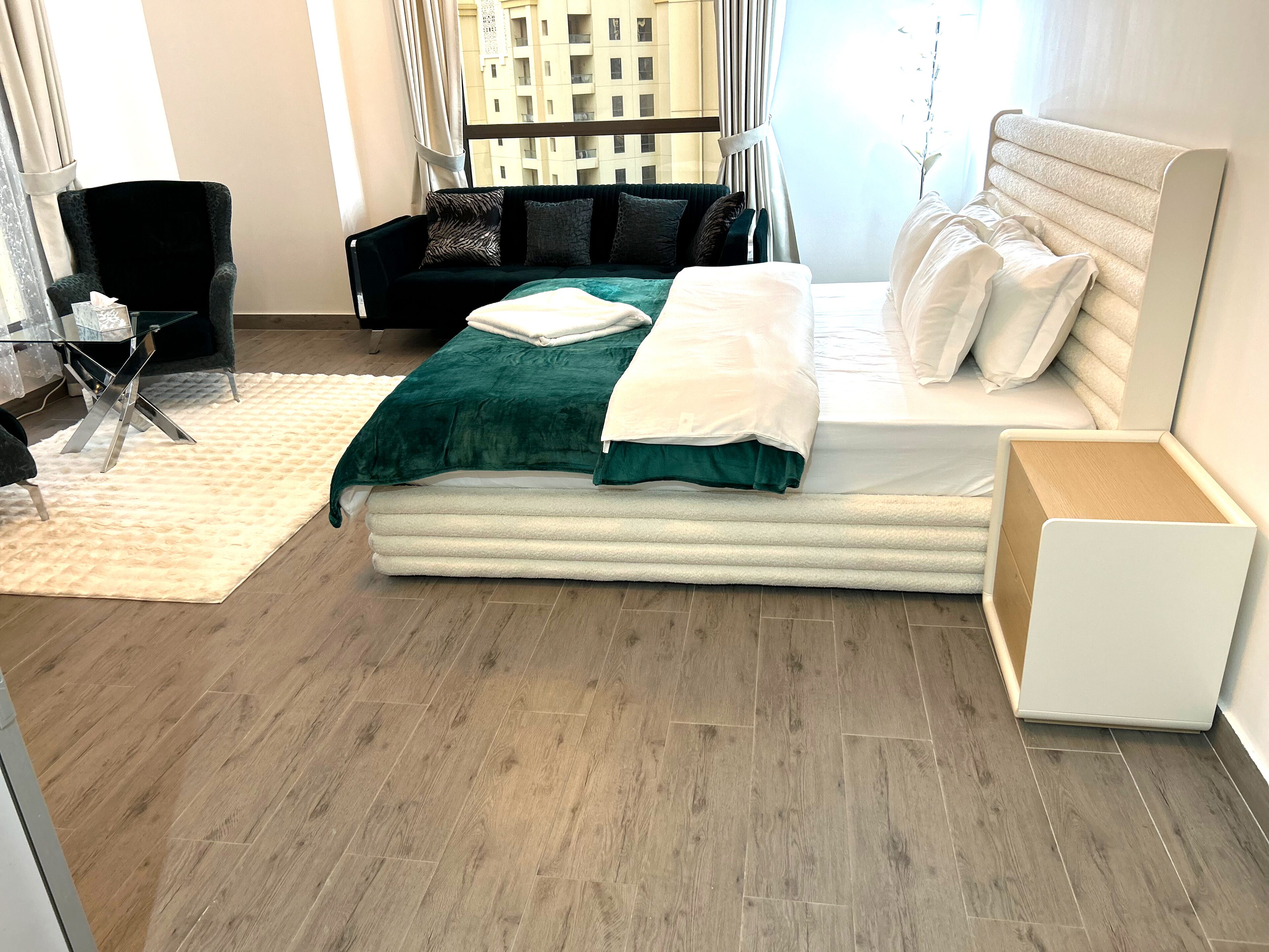 A modern bedroom with a bed, a chair, and a small table.